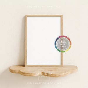 May include: A wooden framed picture frame with a white interior, resting on a wooden shelf with a cloud-like design. A color wheel graphic with the text "ONE MOCKUP, MANY LOOKS!" is on the right. The text "MOCKUP HAUS CO" is at the bottom.