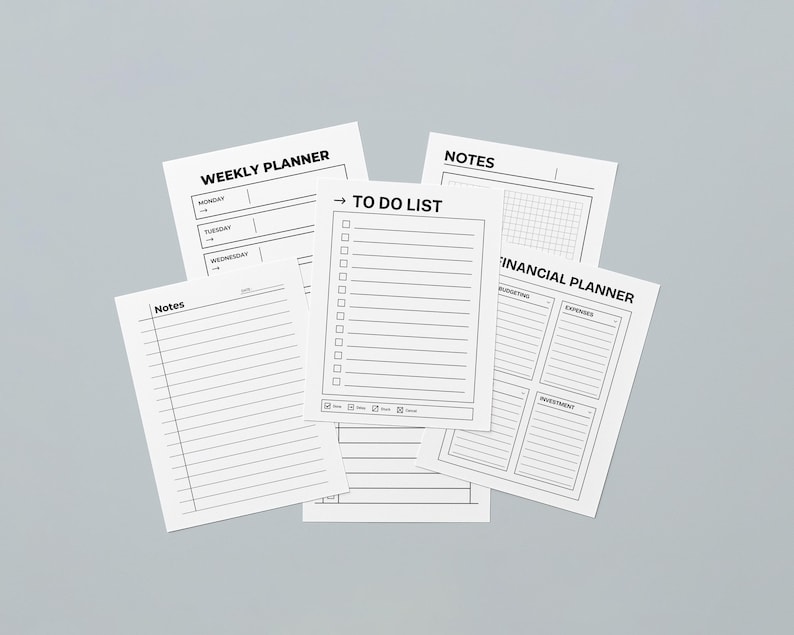 May include: A selection of white paper sheets featuring black text, such as a weekly planner, to-do list, notes, and a financial planner. The sheets are displayed against a light grey backdrop. The planner pages are designed for organization.