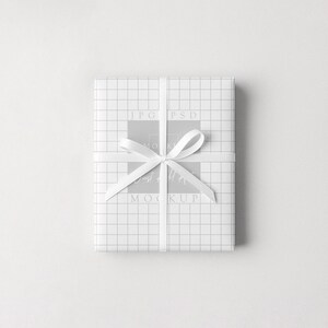 Puede incluir: Un regalo envuelto con papel blanco con un patr&oacute;n de cuadr&iacute;cula, atado con una cinta y un lazo blancos. El regalo est&aacute; centrado sobre un fondo blanco.
