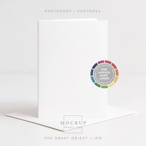 Könnte beinhalten: Eine weiße Klappkarte mit passendem Umschlag, präsentiert auf einer weißen Oberfläche. Die Karte zeigt oben den Text "PHOTOSHOP • PHOTOPEA" und "ONE MOCKUP MANY LOOKS!" in einem kreisförmigen Design. Der untere Teil der Karte trägt den Text "MOCKUP HAUS CO" und "PSD SMART OBJECT • JPG".