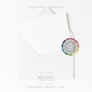 May include: A white envelope with a white card inside, set against a white backdrop. A colour wheel graphic with the text "ONE MOCKUP MANY LOOKS!" is on the right. The text "MOCKUP HAUS CO." and "PSD SMART OBJECT . JPG" are at the bottom.
