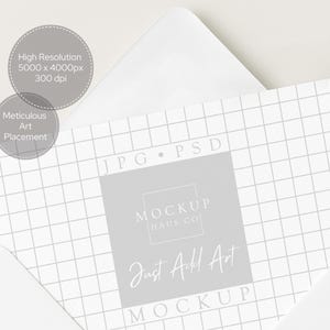 May include: A white envelope partially open, revealing a grid-patterned card with the text "MOCKUP HAUS CO" and "Just Add Art". The card is light gray with a grid pattern. Two gray circles with text are in the upper left.