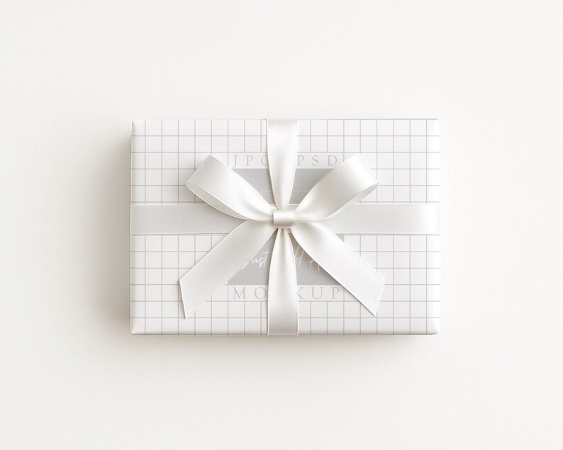 May include: A rectangular gift box wrapped in white paper with a grid pattern. A wide, light gray ribbon is wrapped around the box, tied in a bow. The background is plain white.