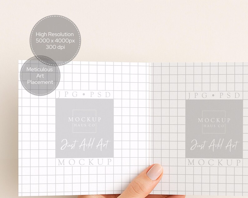 May include: A mockup image of an open book or brochure, held by a hand. The pages have a grid pattern. The text on the pages reads "MOCKUP HAUS CO" and "Just Add Art". Additional text indicates "High Resolution 5000 x 4000px 300 dpi" and "Meticulous Art Placement".