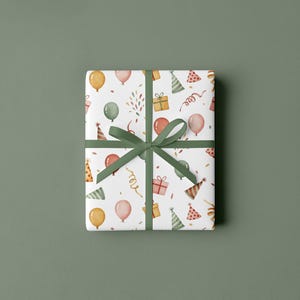 Puede incluir: Un regalo envuelto con un fondo blanco que presenta un patr&oacute;n de sombreros de fiesta, globos, confeti y regalos envueltos. El regalo est&aacute; atado con una cinta verde. El fondo es verde liso y apagado.
