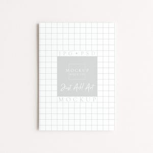 May include: A white notebook with a grid pattern and the text "JPG &bull; PSD" at the top. The center features a gray square with the text "MOCKUP HAUS CO." and "Just Add Art MOCKUP" in a handwritten font.