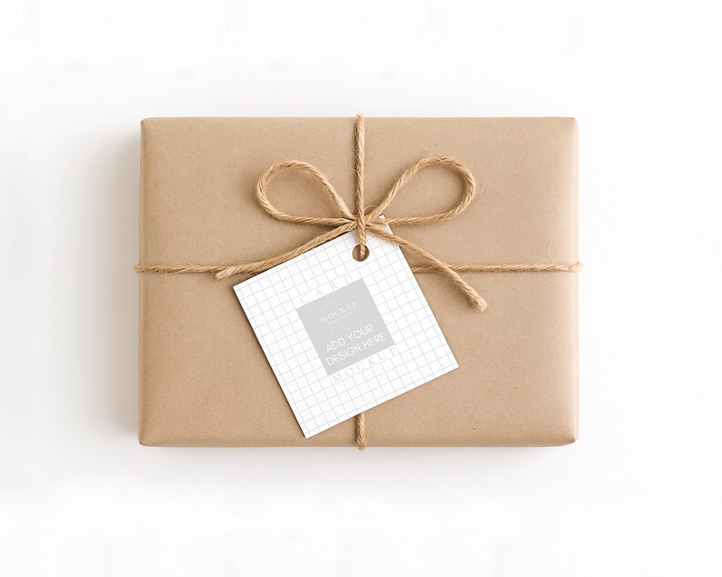 May include: A rectangular gift wrapped in brown paper, tied with twine, and a tag that says "ADD YOUR DESIGN HERE". The tag has a grid pattern and a grey square. The twine is tied in a bow.