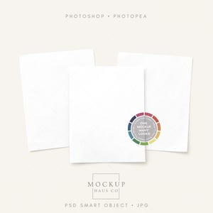 May include: Three white rectangular cards with a subtle grid pattern, arranged on a light beige background. A colorful circular graphic with the text "ONE MOCKUP MANY LOOKS" is on one card. The text "MOCKUP HAUS CO" is at the bottom.