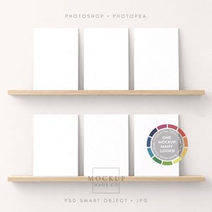 May include: Six blank white rectangular frames arranged on two light wood shelves. The text "PHOTOSHOP • PHOTOPEA" appears at the top, and a circular graphic with the text "ONE MOCKUP, MANY LOOKS!" is on the bottom right frame. "MOCKUP HAUS CO" is centred below.