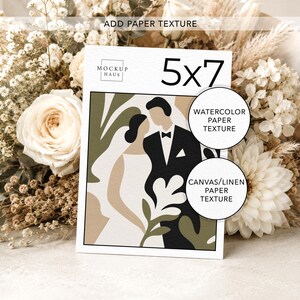 Pu&ograve; includere: Una stampa artistica per matrimoni di 5x7 pollici con un'illustrazione minimalista di una sposa e uno sposo in tonalit&agrave; neutre. La stampa &egrave; circondata da un bouquet di fiori bianchi e beige. Il testo "ADD PAPER TEXTURE" &egrave; visibile in alto.