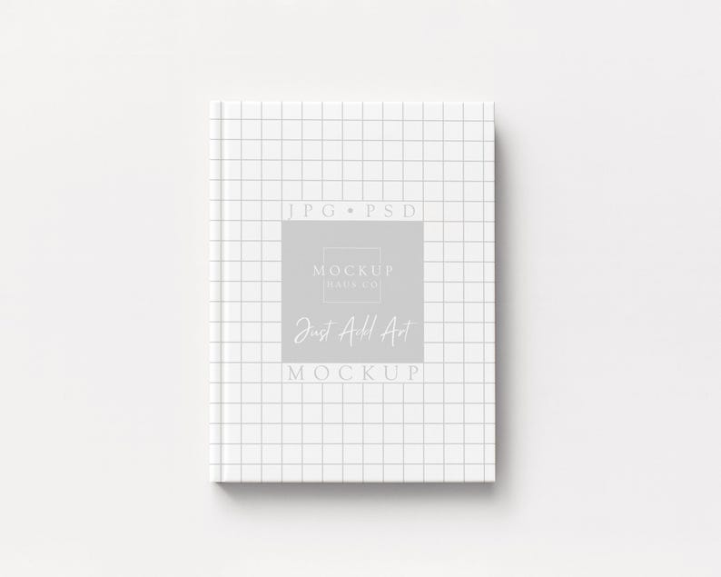 May include: A white notebook with a grid pattern on the cover. The notebook has the text "JPG PSD" at the top and "Mockup Daily Co" and "Just All Art Mockup" in a gray rectangle in the center.