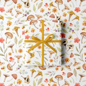 May include: White wrapping paper with a repeating pattern of watercolor mushrooms, flowers, and leaves. A wrapped gift is tied with a yellow ribbon. The design features orange, yellow, and brown tones.