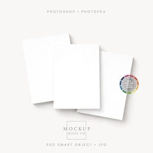 Op de afbeelding: Drie witte rechthoekige kaarten in een hoek, met een kleurenwiel en de tekst "ONE MOCKUP MANY LOOKS". De kaarten staan op een lichtbeige achtergrond. De tekst "MOCKUP HAUS CO" en "PSD SMART OBJECT • JPG" zijn ook zichtbaar.