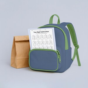 May include: A blue backpack with green accents and straps, a brown paper lunch bag, and a worksheet titled "Two Digit Subtraction" are displayed. The worksheet is visible in the front pocket of the backpack.