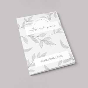 May include: A white planner with a botanical leaf pattern and the text "Planner 2020 notes and plans." The name "Samantha Lopez" is printed on the bottom. The cover design features a minimalist aesthetic with gray line art.