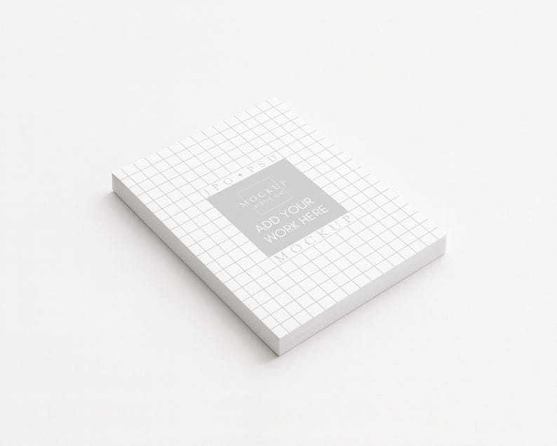 Peut inclure: Une pile de papier blanc avec un motif quadrill&eacute;, inclin&eacute;e sur une surface blanche. Un carr&eacute; gris avec le texte "ADD YOUR WORK HERE" est centr&eacute; sur le dessus. Les mots "JPG PSD" et "MOCKUP" sont &eacute;galement visibles.