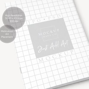 May include: A white notebook with a grid pattern, featuring the text "Just Add Art" and "Mockup" in a soft, elegant font. The image also includes text indicating high resolution and meticulous art placement.