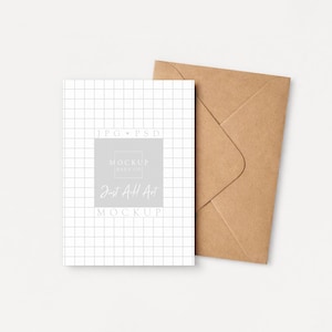May include: A white card with a grid pattern and text that reads "Just All Art Mockup" is next to a brown envelope. The card has a light gray square with the text "Mockup Pays Co." The background is a solid off-white color.