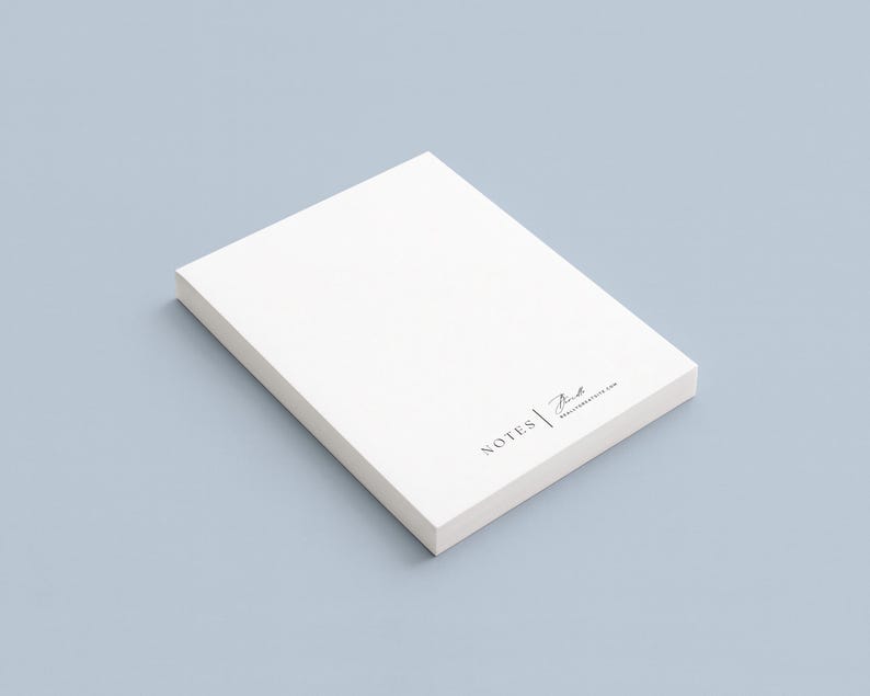 Peut inclure: Un bloc-notes blanc rectangulaire sur une surface bleu clair. Le papier a un design minimaliste. Le coin inf&eacute;rieur droit du papier porte le mot "NOTES" et une signature en noir. Le fond est bleu clair uni.