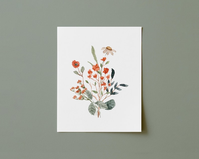May include: Watercolor painting of a floral arrangement featuring orange and red flowers, green leaves, and a single daisy. The artwork is on a white background, with a soft, natural aesthetic. The painting is centered on a white rectangular paper.