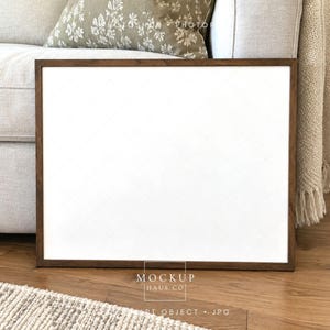 Op de afbeelding: Een rechthoekige fotolijst met een donkerbruine houten rand en een leeg wit midden. De lijst is horizontaal geplaatst en heeft een schoon, vlak oppervlak voor het weergeven van kunstwerken of foto's, met een eenvoudig en strak ontwerp.