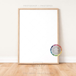 May include: A vertical wooden picture frame with a white interior, leaning against a white wall. The frame is on a wooden floor. A color wheel graphic is on the lower right. The text "Photoshop • Photopea" is at the top.