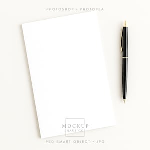 May include: A blank white notepad with a black pen with gold accents. The pen is positioned to the right of the notepad. The words "Photoshop • Photopea" are at the top. The words "Mockup Haus Co" are at the bottom.