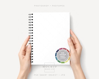 May include: A white spiral-bound notebook with a black wire coil. A circular sticker on the cover features a color wheel design with the text "ONE MOCKUP, MANY LOOKS!" and "Choose Your Colors, Adapt To Your Brand, Match Your Design".