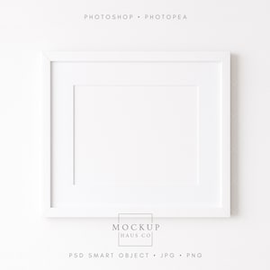 May include: A white rectangular picture frame with a white mat. The frame is centered on a white background. The text "PHOTOSHOP • PHOTOPAE" is at the top. The text "MOCKUP HAUS CO" is at the bottom, along with "PSD SMART OBJECT • JPG • PNG".