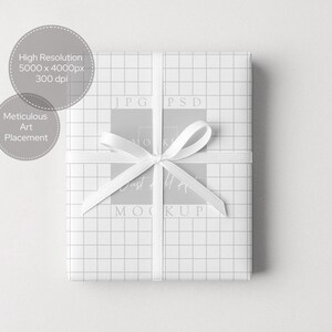 Puede incluir: Un regalo envuelto en papel blanco con un patr&oacute;n de cuadr&iacute;cula y una cinta de raso blanca atada con un lazo. El regalo est&aacute; centrado sobre un fondo blanco. La imagen incluye el texto "High Resolution 5000 x 4000px 300 dpi" y "Meticulous Art Placement."