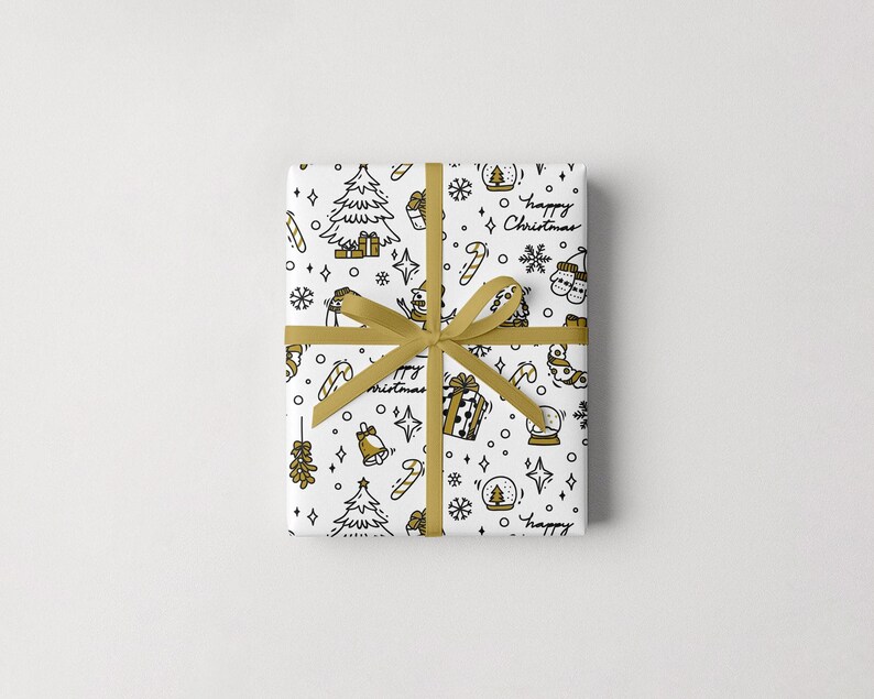 Puede incluir: Un regalo envuelto con un fondo blanco y una cinta dorada. El papel de regalo presenta un patr&oacute;n repetido de ilustraciones navide&ntilde;as en negro y dorado, incluyendo &aacute;rboles, regalos y las palabras "happy Christmas".