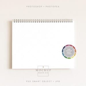 Può includere: Un blocco note bianco a spirale con una pagina vuota, ideale per i mockup. Il blocco note ha una spirale in metallo argentato e una grafica a ruota dei colori con la scritta "One Mockup Many Looks!". Le parole "Photoshop" e "Photopea" sono in alto.