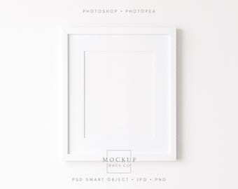 May include: A white square picture frame with a white mat. The frame is centered on a white background. The text "PHOTOSHOP • PHOTOPEA" is at the top, and "MOCKUP HAUS CO" is at the bottom. Below the text is "PSD SMART OBJECT • JPG • PNG".