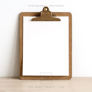 May include: A brown clipboard with a brass clip holds a blank white sheet of paper. The words "PHOTOSHOP • PHOTOPEA" are at the top, and "MOCKUP HAUS CO" and "PSD SMART OBJECT • JPG" are at the bottom.