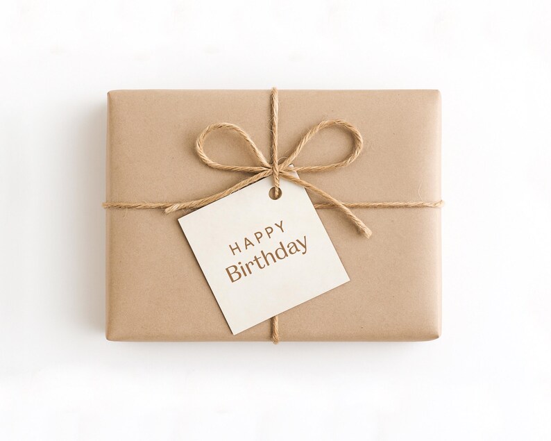 May include: A rectangular gift wrapped in brown paper, tied with twine, and decorated with a twine bow. A cream-coloured tag with the words "HAPPY Birthday" is attached to the bow.