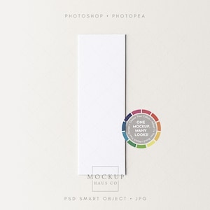 May include: A vertical white rectangular card with a subtle diamond pattern, positioned on a light beige surface. A colorful circular design with the text "ONE MOCKUP MANY LOOKS!" is on the right. The words "PHOTOSHOP • PHOTOPEA" are at the top.