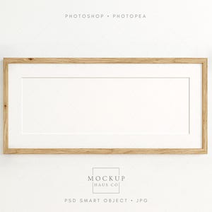 May include: A rectangular wooden picture frame with a white mat. The frame is made of light-colored wood and has a simple, clean design. The image includes the text "PHOTOSHOP • PHOTOPAE" at the top and "MOCKUP HAUS CO" and "PSD SMART OBJECT • JPG" at the bottom.