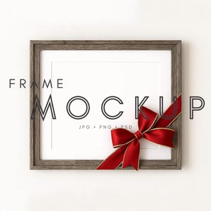Könnte beinhalten: Ein quadratischer Holzrahmen-Mockup mit dem Text "FRAME MOCKUP" und einem roten Band, das zu einer Schleife gebunden ist. Der Rahmen hat einen weißen Innenraum und ist vor einem weißen Hintergrund platziert. Der Text "JPG • PNG • PSD" ist ebenfalls sichtbar.