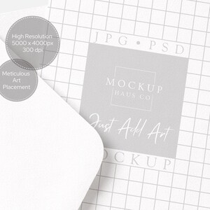 Puede incluir: Un sobre blanco que cubre parcialmente un fondo de cuadr&iacute;cula gris con el texto "JPG PSD" y "MOCKUP HAUS CO Just Add Art". Dos c&iacute;rculos grises con texto: "Alta resoluci&oacute;n 5000 x 4000px 300 dpi" y "Colocaci&oacute;n de arte meticulosa".