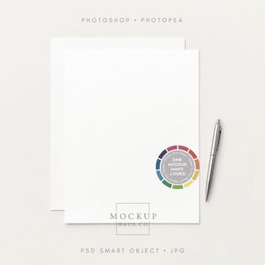 Könnte beinhalten: Ein Mockup mit zwei weißen Papierblättern mit einem dezenten Gittermuster, einem silbernen Stift und einem farbenfrohen kreisförmigen Design mit dem Text "ONE MOCKUP MANY LOOKS". Die Wörter "PHOTOSHOP • PHOTOPEA", "MOCKUP HAUS CO" und "PSD SMART OBJECT • JPG" sind ebenfalls sichtbar.