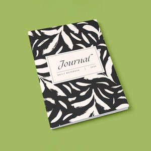May include: A closed journal with a black and white abstract leaf pattern. The journal has a rectangular label with the word "Journal" and the year "2020". The words "Daily Notebook" are also printed on the label.