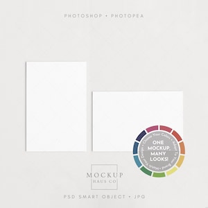 May include: A mockup featuring two white rectangular cards, one vertical and one horizontal, against a light background. A color wheel graphic with the text "ONE MOCKUP, MANY LOOKS!" is on the right. The text "MOCKUP HAUS CO" and "PSD SMART OBJECT . JPG" are also visible.