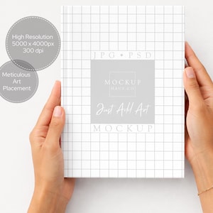 K&ouml;nnte beinhalten: Ein wei&szlig;es Buchcover-Mockup mit einem Rastermuster, gehalten von H&auml;nden. Das Cover zeigt den Text "JPG PSD" und "Just Add Art". Graue Kreise weisen auf "Hohe Aufl&ouml;sung" und "Sorgf&auml;ltige Kunstplatzierung" hin.
