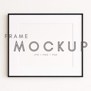 以下が含まれることがあります： ミニマリストフォントで「FRAME MOCKUP」というテキストが表示された、白いマットが付いた長方形の黒いフレーム。テキストの下には、JPG、PNG、PSDのファイルタイプがあります。フレームは白い背景に配置されています。
