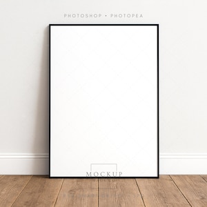 Maquette d'affiche avec cadre noir DIN A appuyée sur le mur sur un sol en bois rustique PSD