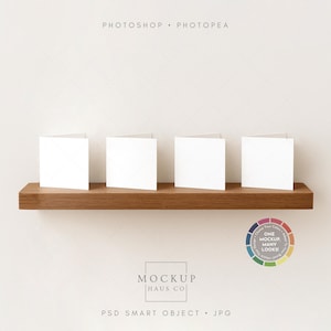Może przedstawiać: Cztery puste białe kwadratowe karty są wyświetlane na ciemnej drewnianej półce na białym tle. Półka jest zamontowana na ścianie. Obraz zawiera tekst "PHOTOSHOP • PHOTOPEA" i "MOCKUP HAUS CO". Widoczne jest również koło kolorów.