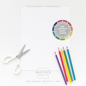May include: A flat lay featuring a white sheet of paper with a pair of white-handled scissors, a set of colored pencils, and a color wheel graphic. The text "PHOTOSHOP • PHOTOPEA" is at the top.