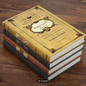 May include: A stack of four vintage-style notebooks with gold-colored covers. The top notebook features the text "Magic Spells Purebook" and "Precious memories". The other notebooks are in shades of gray, brown, and blue. The bottom right corner shows the text "4 Color".