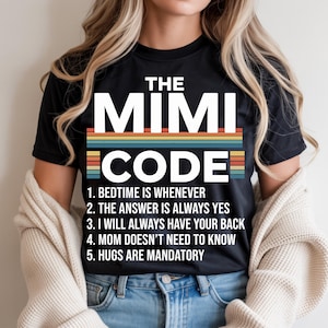 May include: Black t-shirt with the text "THE MIMI CODE" in white block letters above a retro-style stripe design. Below, the shirt lists five rules in white text, including "BEDTIME IS WHENEVER" and "HUGS ARE MANDATORY."