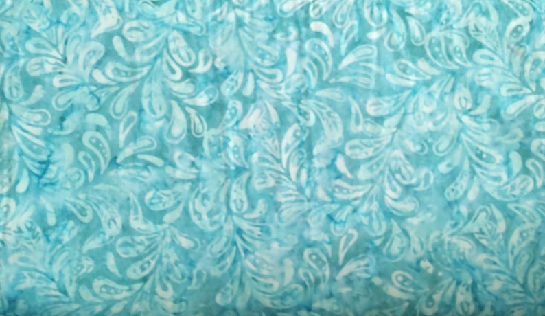 May include: A close-up of a fabric with a repeating pattern of white, stylized leaves and swirls against a light blue background. The fabric has a watercolor-like effect, with variations in the blue tones.